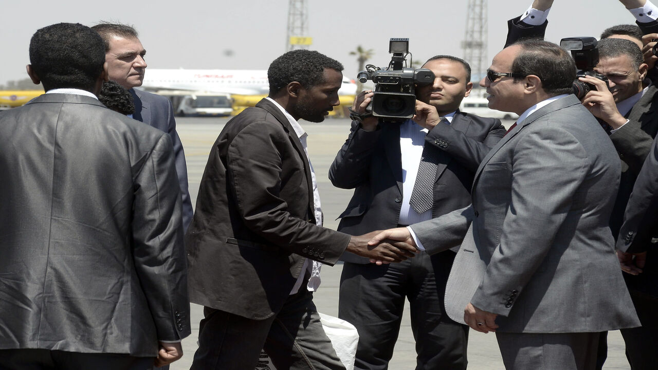 Egyptian President Abdel Fattah al-Sisi (R) receives an Ethiopian man who Sisi said was "rescued" from war-torn Libya alongside 26 of his compatriots by Egypts security services upon their arrival at Cairo airport on May 7, 2015. It was not immediately clear how the Ethiopians were rescued, but Sisi's office said the group flown in on an Egyptian plane was "liberated by Egyptian and Libyan security services". AFP PHOTO / STR        (Photo credit should read STR/AFP via Getty Images)