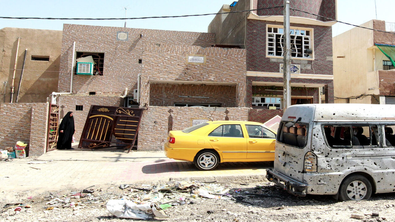 An Iraqi woman looks at the damage outside her house in a residential area of the capital, Baghdad, on July 13, 2015, the day after a car bomb explosion. A string of bomb explosions, including two suicide attacks, killed at least 21 people and wounded 62 in Shiite-dominated neighbourhoods of Baghdad, Iraqi police and medical sources said.  AFP PHOTO / SABAH ARAR        (Photo credit should read SABAH ARAR/AFP via Getty Images)