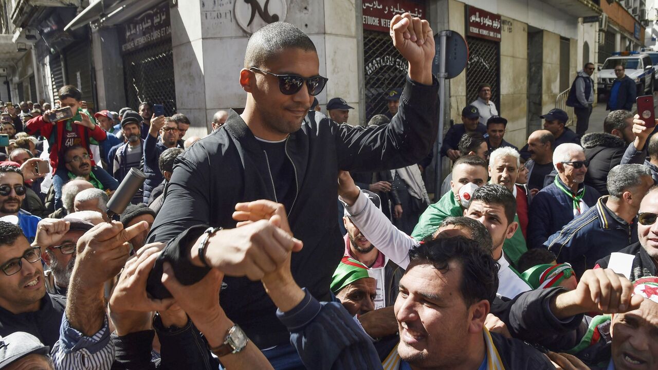 A picture taken on March 6, 2020 shows Algerian protesters carrying journalist Khaled Drareni on their shoulders after he was briefly detained by security forces in the Algerian capital Algiers. - Drareni was arrested on March 7 while covering an anti-government protest, accused of "inciting an unarmed gathering and damaging national integrity". (Photo by RYAD KRAMDI / AFP) (Photo by RYAD KRAMDI/AFP via Getty Images)