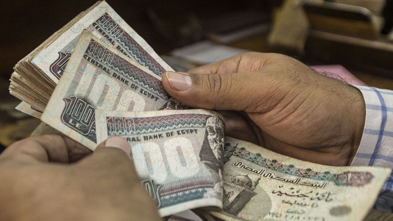 A man counts Egyptian pounds at currency exchange shop in downtown Cairo on November 3, 2016. - Egypt floated the country's pound as part of a raft of reforms, after a dollar crunch and exorbitant black market trade threatened to grind some imports to a halt. (Photo by KHALED DESOUKI / AFP) (Photo by KHALED DESOUKI/AFP via Getty Images)