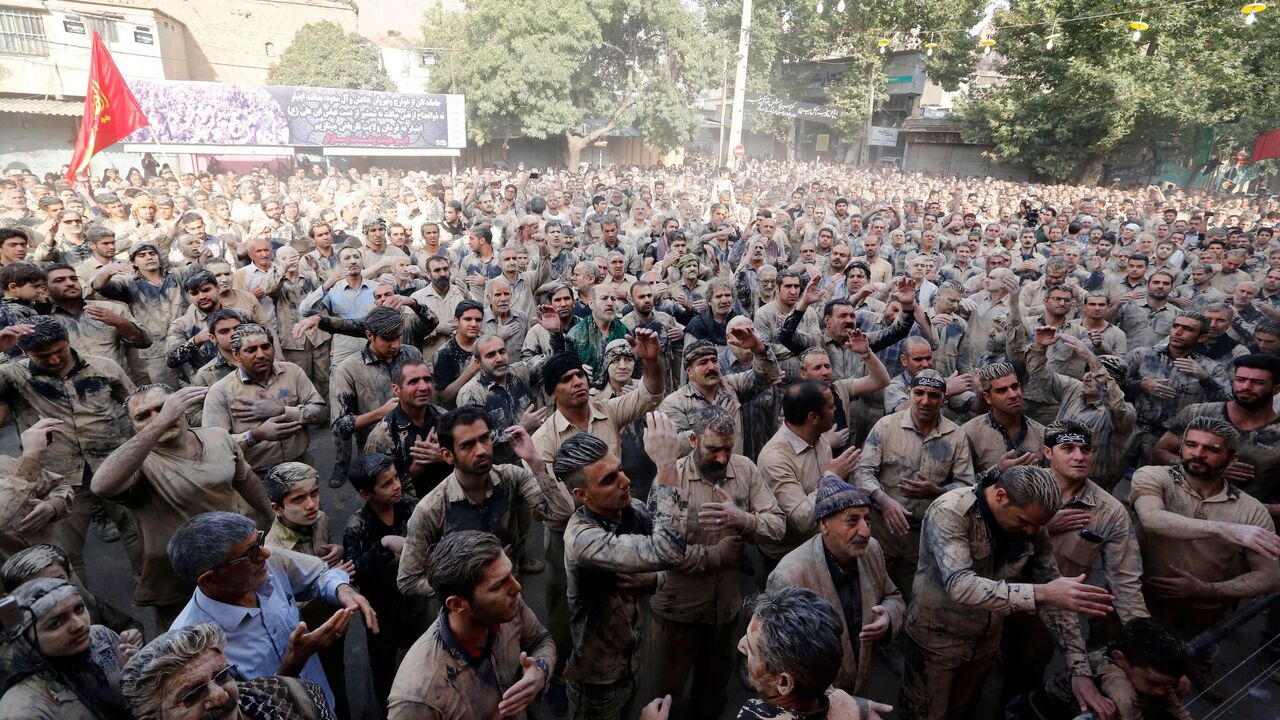 Iranian Shiite Muslims beat their chests as they take part in the 'Kharrah Mali' (Rubbing Mud) ritual during the Ashura religious ceremony in the city of Khorramabad, 470 kms southwest of Tehran, on October 01, 2017.
"Khrreh Mali" or "Mud Rubbing" is a ritual that is held in the city of Khorramabad every year to commemorate the seventh century slaying of Prophet Mohammed's grandson Imam Hussein, in which Iranian men roll over in mud and dry themselves by gathering around the bonfires before flagellating the