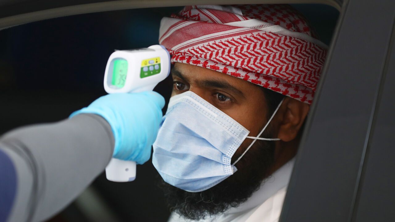 ABU DHABI, UNITED ARAB EMIRATES - APRIL 01:   A medical worker, wearing disposable gloves ,  measures the temperature of a man at a coronavirus drive-through screening center on April 01, 2020 in Abu Dhabi, United Arab Emirates. The Coronavirus (COVID-19) pandemic has spread to many countries across the world, claiming over 40,000 lives and infecting hundreds of thousands more. (Photo by Francois Nel/Getty Images)