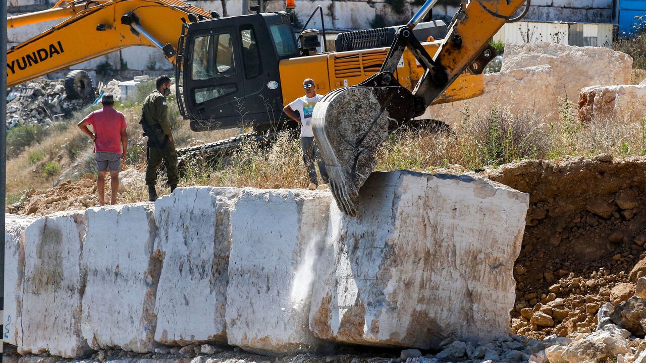 Israeli earth movers remove concrete blocks along the side of a road lying in "Area C" of the occupied West Bank where Israeli administers full civil and security control, in the flashpoint city of Hebron on July 2, 2020. (Photo by HAZEM BADER / AFP) (Photo by HAZEM BADER/AFP via Getty Images)