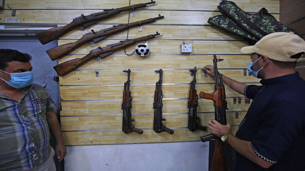Employees display rifles for sale at a gun shop in the Iraqi capital Baghdad on September 22, 2020. (Photo by AHMAD AL-RUBAYE / AFP) (Photo by AHMAD AL-RUBAYE/AFP via Getty Images)