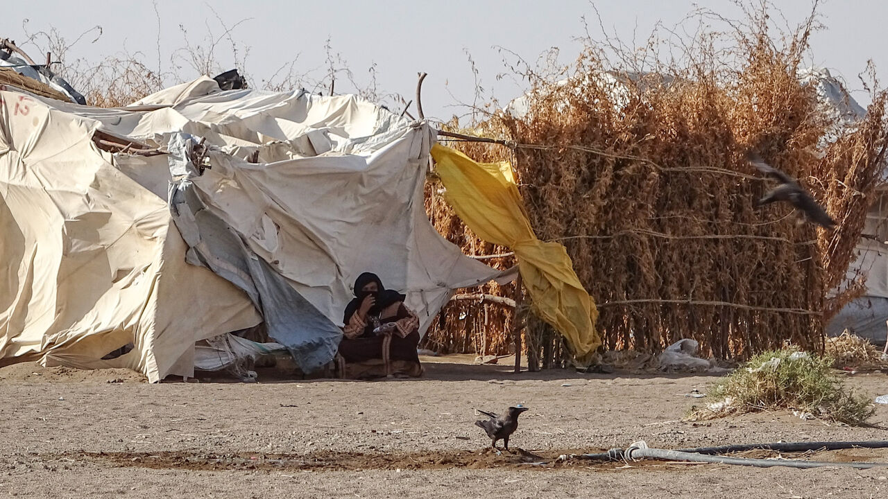 A woman sits outside a tent at a displaced persons camp in the Khokha district of Yemen's western province of Hodeida, on May 6, 2020. - Almost six years of war between the Yemeni government and tenacious Iran-backed Huthi rebels has pushed millions to the brink of famine in the country ill prepared to face the new threat. Squalid camps for internally displaced people like the one in Al-Khokha, outside the Red Sea port city of Hodeida, are ideal breeding grounds for disease, with little chance for proper sa