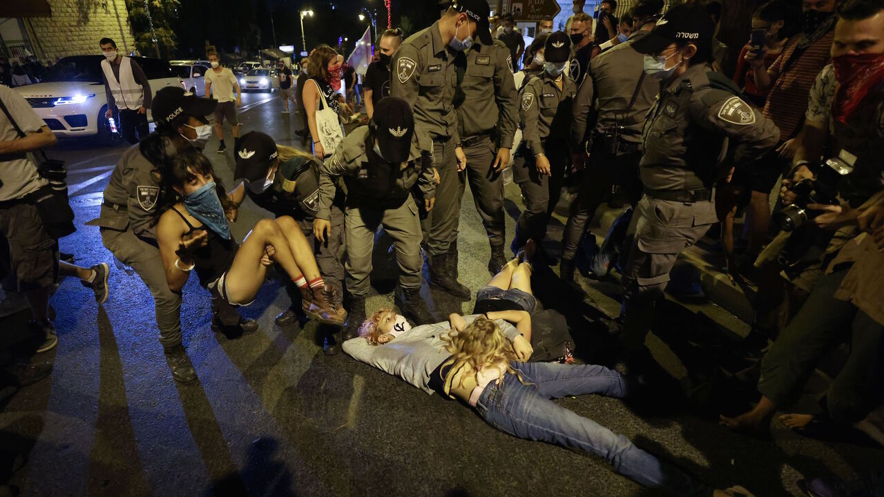 Police carry away a protester during an anti-government demonstration in front of the Prime Minister's residence in Jerusalem on August 29, 2020. - Protests demanding that Israeli Prime Minister Benjamin Netanyahu resign over several corruption indictments and his handling of the coronavirus crisis have been mounting in recent weeks, and the premier has been scathing in his counter-attack. (Photo by Emmanuel DUNAND / AFP) (Photo by EMMANUEL DUNAND/AFP via Getty Images)