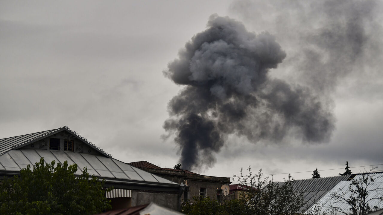 TOPSHOT - Smoke rises behind houses after shelling in the breakaway Nagorno-Karabakh region's main city of Stepanakert on October 7, 2020, during the ongoing fighting between Armenia and Azerbaijan over the disputed region. (Photo by ARIS MESSINIS / AFP) (Photo by ARIS MESSINIS/AFP via Getty Images)