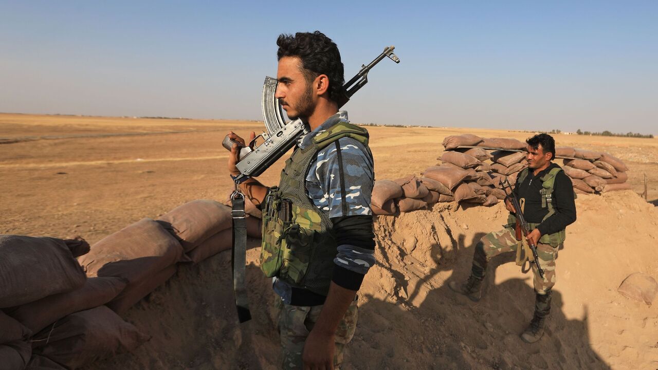 Turkey-backed Syrian fighters man a sand barricade near the rebel-controlled town of Tal Abyad in the northern Syria's Raqa province, along the frontline with Syrian Kurdish forces controling the Kurdish-majority city of Kobani, on October 10, 2020. (Photo by Bakr ALKASEM / AFP) (Photo by BAKR ALKASEM/AFP via Getty Images)