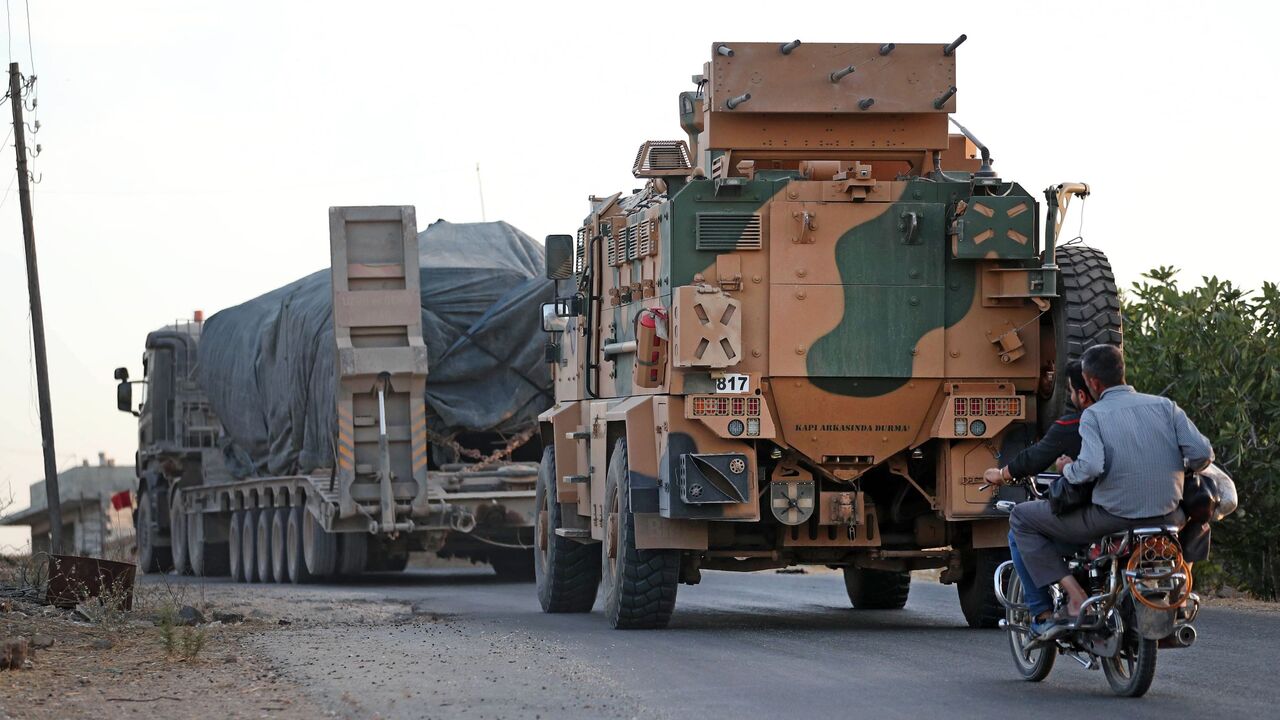 A Turkish military convoy drives through the village of Iblin, near Ariha in Syria's rebel-held northwestern Idlib province on October 20, 2020 after vacating the Morek post in Hama's countryside. - Turkey started withdrawing from one of its largest outposts in northwest Syria encircled for the past year by Syrian regime forces, a war monitor and a pro-Ankara rebel commander said. The outpost in Morek is Turkey's largest in the northwest province of Hama, which is now mostly under Syrian government control.