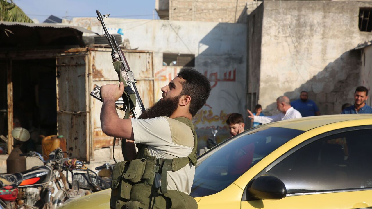 A fighter with the Turkey-backed Faylaq al-Sham rebel faction in Syria shoots in the air during the funeral of 10 of the faction's fighters in the northwestern city of Idlib, on October 26, 2020, following their death in a Russian air strike. - Air strikes by Syrian regime ally Russia killed 78 fighters from the turkey-backed Faylaq al-Sham faction when they targeted a training camp in the Jabal Duwayli area in Idlib province, the Syrian Observatory for Human Rights said. (Photo by Mohammed AL-RIFAI / AFP) 