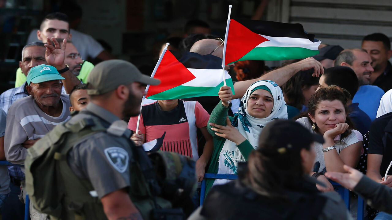 Palestinian demonstrators are separated by Israeli police barriers from Israelis celebrating Jerusalem Day, that marks the anniversary of the "reunification" of the holy city after Israel captured the Arab eastern sector from Jordan during the 1967 Six-Day War,  outside Damascus Gate in Jerusalem's old city on June 5, 2016. 

Israel occupied east Jerusalem in 1967 and later annexed it in a move never recognized by the international community. / AFP / AHMAD GHARABLI        (Photo credit should read AHMAD GHA