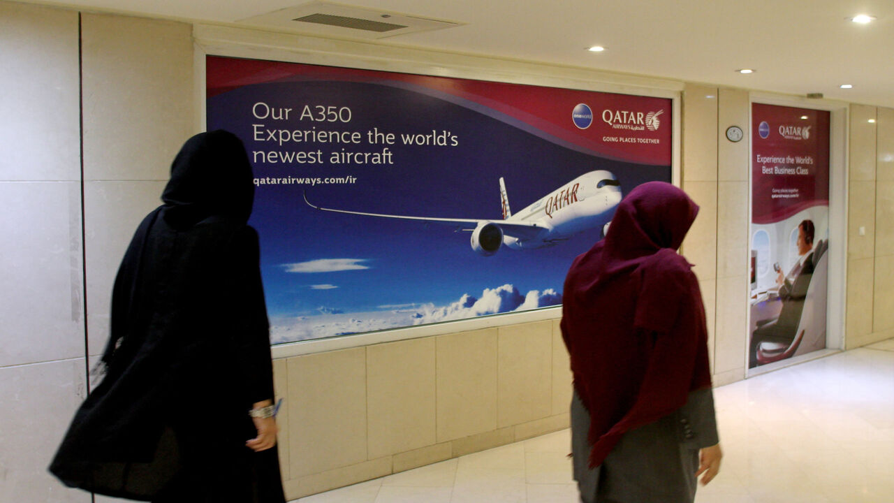Iranian women walk past a Qatar Airways branch in the capital Tehran on June 6, 2017.
A ban on Qatari flights imposed by Saudi Arabia and its allies took effect as first efforts were made to resolve the biggest feud to hit the Arab world in years. Saudi Arabia and allies including Egypt, the United Arab Emirates and Bahrain cut diplomatic ties and transport links with Qatar on Monday, accusing the Gulf state of supporting extremism.
 / AFP PHOTO / ATTA KENARE        (Photo credit should read ATTA KENARE/AFP