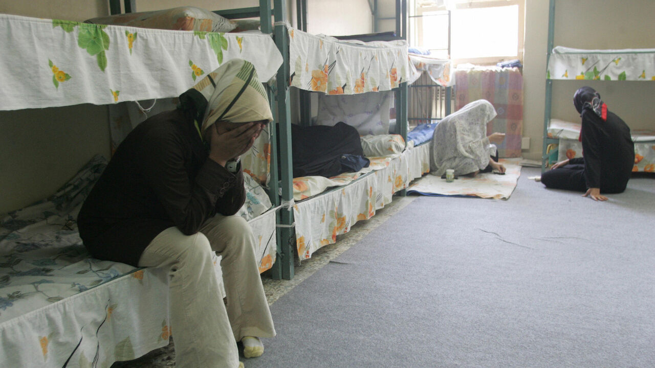 Tehran, IRAN:  TO GO WITH AFP STORY IRAN-JUSTICE-PRISON-SOCIT BY PIERRE CELERIER  Iranian women inmates sit at their cell in the infamous Evin jail, north of Tehran, 13 June 2006. AFP PHOTO/ATTA KENARE  (Photo credit should read ATTA KENARE/AFP via Getty Images)