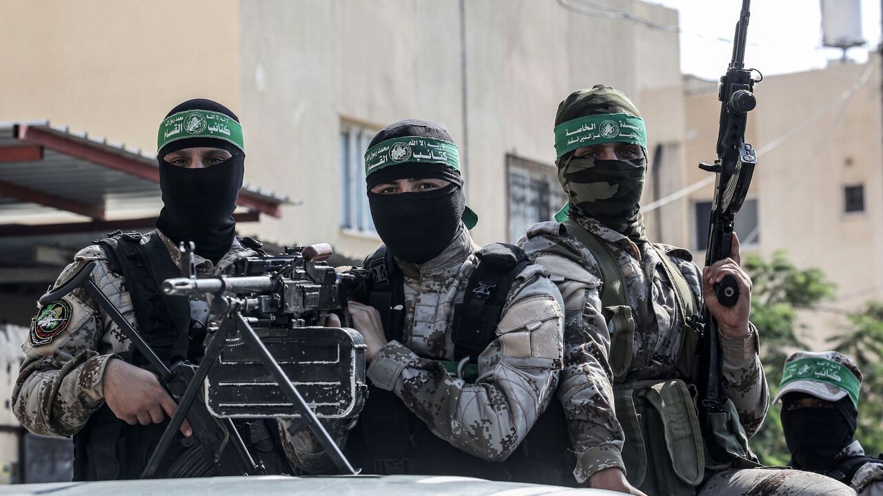 A masked Hamas militant mans a machine gun as he stands with others in the back of a pickup truck during a celebration of the release of Abdel Halim Badawi (unseen), a Palestinian who was held for 18 years in an Israeli prison after he was convicted of being a member of Hamas' armed wing in 2001, in Rafah in the southern Gaza Strip on October 17, 2019. (Photo by SAID KHATIB / AFP) (Photo by SAID KHATIB/AFP via Getty Images)