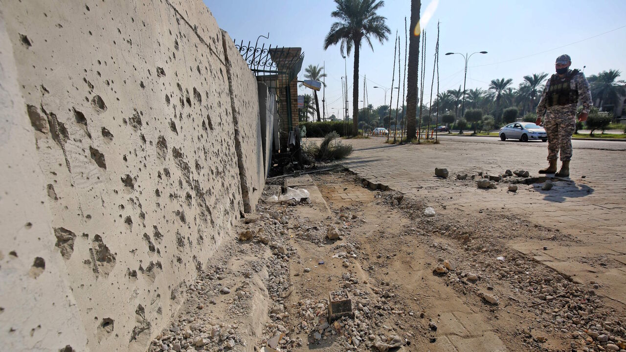 A member of the Iraqi security forces inspects the damage outside the Zawraa park in the capital Baghdad on November 18, 2020, after volley of rockets slammed into the Iraqi capital breaking a month-long truce on attacks against the US embassy. - According to the Iraqi military, four of the rockets landed in the high-security Green Zone, where the US embassy and other foreign missions are based.  Another three rockets also hit other parts of Baghdad, killing one girl and wounding five civilians. All seven r