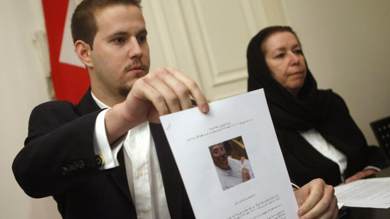 US Daniel Levinson (L) shows a picture of his father, ex-FBI agent Robert Levinson, holding his grandson Ryan during a press conference with his mother Christine at the Swiss embassy in Tehran, 22 December 2007. The wife of the former agent missing in Iran since March said today she has received "no answers" about his fate at the end of her trip to the Islamic republic in search of her husband, who Washington says went missing on a visit to the Iranian island of Kish. The Tehran government reiterated earlie