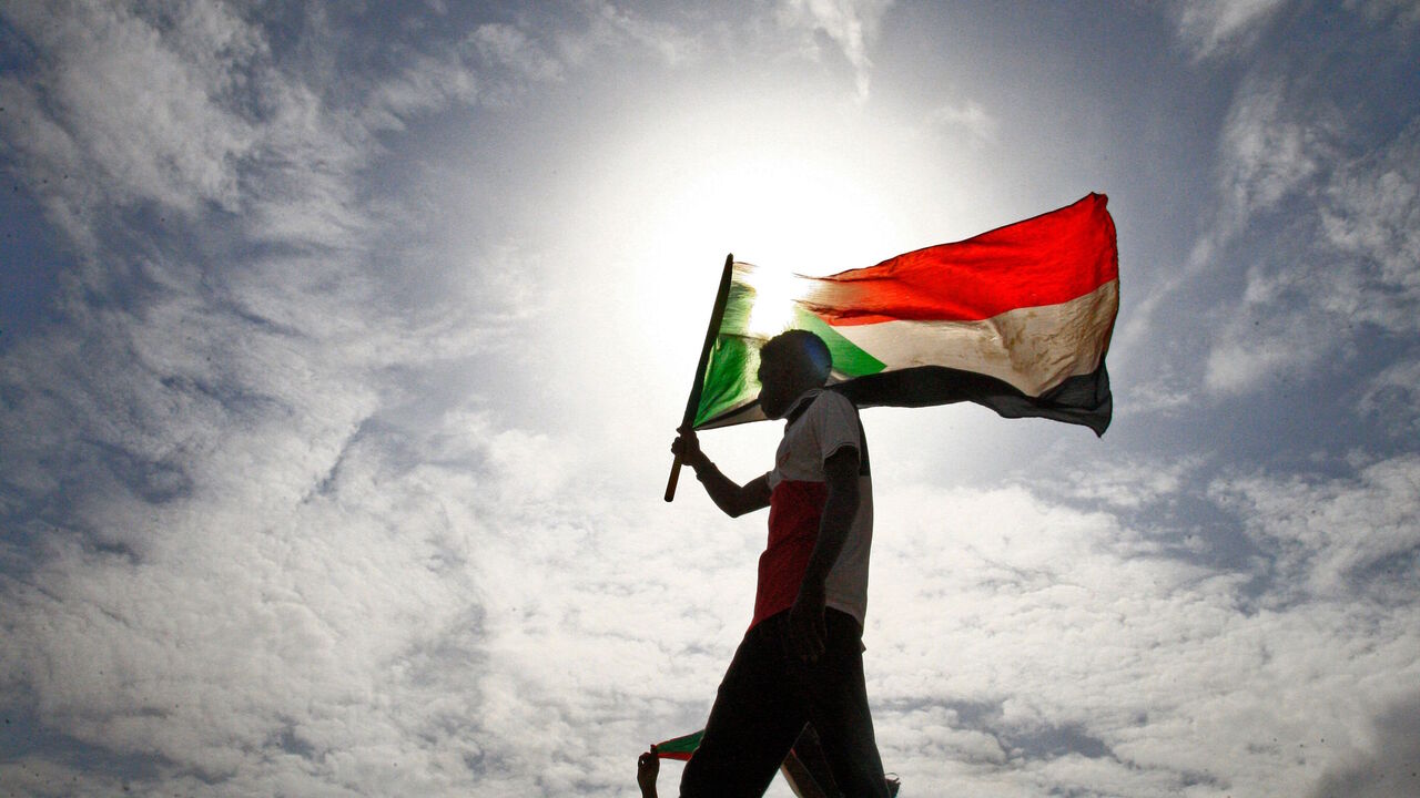 A Sudanese man waves his national flag as he takes part in a demonstration called for by the Sudanese Professionals Association (SPA) to denounce the July 29 Al-Obeid killings, in the capital Khartoum on August 1, 2019. - Thousands of Sudanese demonstrators rallied on August 1 against the killing of four students, as protest leaders and ruling generals were set to resume talks to thrash out remaining issues on transitioning to civilian rule. Tragedy struck Al-Obeid on July 29 when four high school students 