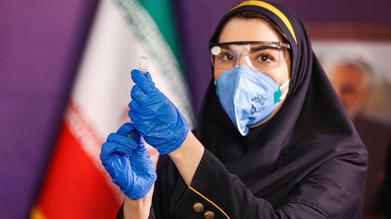 A health worker prepares an injection for a woman during the first trial phase of a locally-made Iranian vaccine for COVID-19 coronavirus disease in Iran's capital Tehran on December 29, 2020. (Photo by - / AFP) (Photo by -/AFP via Getty Images)