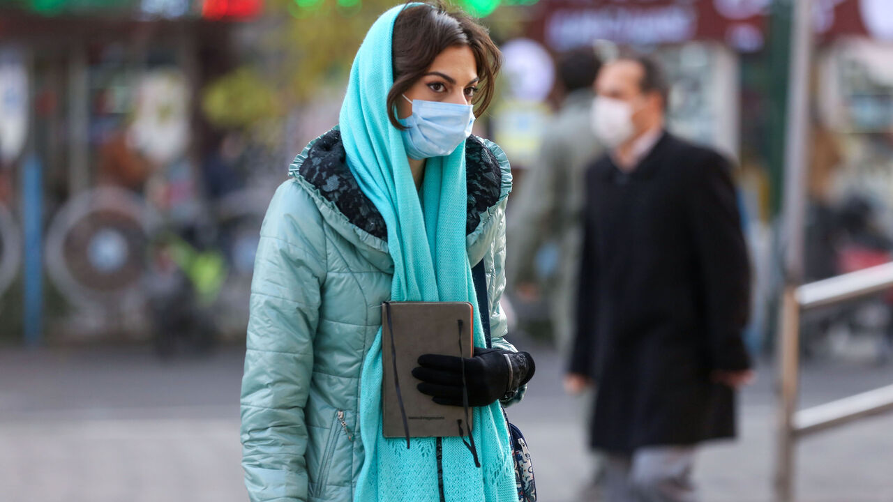 An Iranian woman wearing a protective mask amid the COVID-19 pandemic, walks on a street in the capital Tehran, on December 30, 2020. (Photo by ATTA KENARE / AFP) (Photo by ATTA KENARE/AFP via Getty Images)