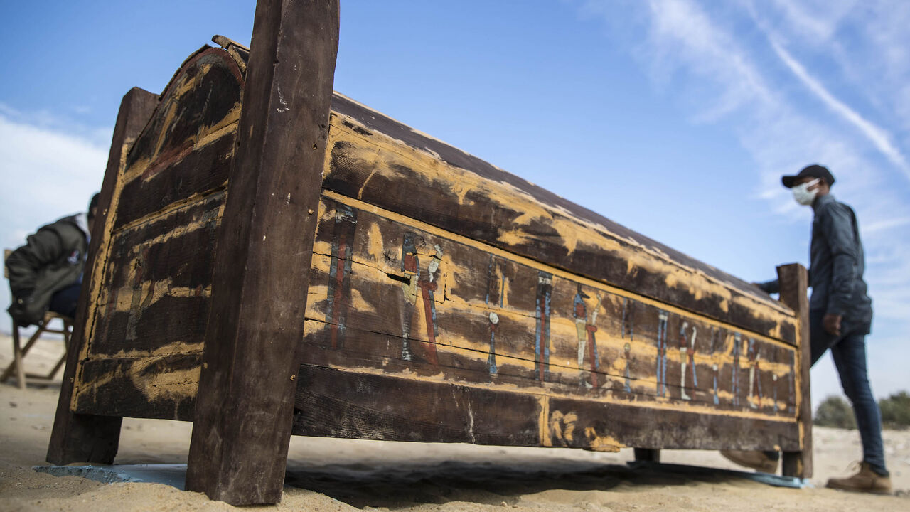 An adorned wooden sarcophagus is displayed during the official announcement of the discovery by an Egyptian archaeological mission of a new trove of treasures at Egypt's Saqqara necropolis south of Cairo, on January 17, 2021. - The discovery at the necropolis which lies 30kms south of the Egyptian capital, includes the funerary temple of Queen Naert, wife of King Teti, as well as burial shafts, coffins, and mummies dating back to the New Kingdom, dating back to nearly 3000 years. (Photo by Khaled DESOUKI / 