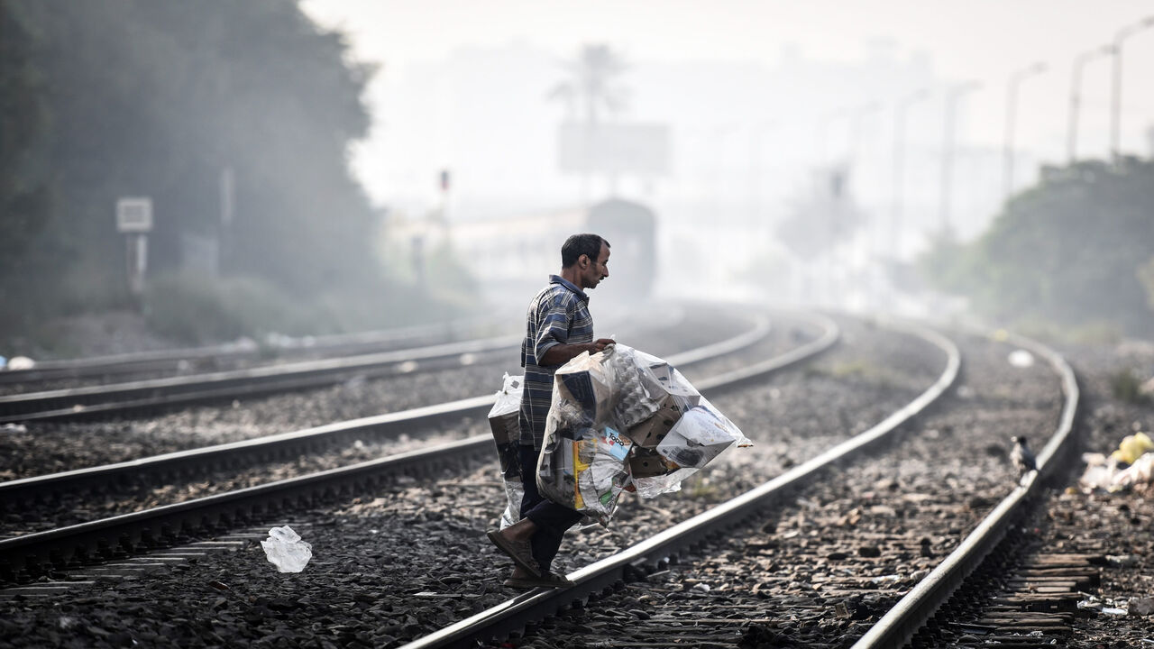 A picture taken on October 11, 2015 shows a man walking on a railway as a train approaches in the Egyptian capital Cairo. AFP PHOTO / MOHAMED EL-SHAHED        (Photo credit should read MOHAMED EL-SHAHED/AFP via Getty Images)