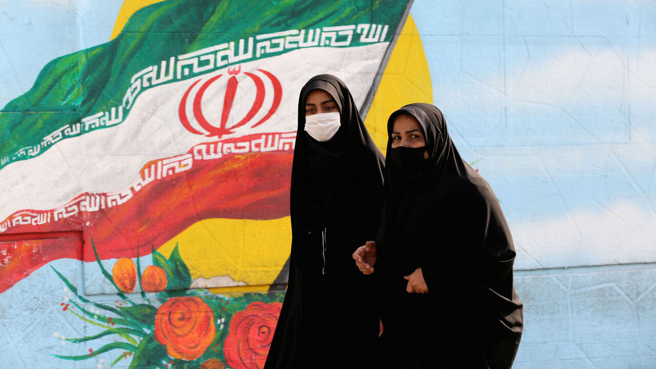 Women walk while wearing face masks amid the COVID-19 pandemic in the Iranian capital Tehran, on November 30, 2020. (Photo by ATTA KENARE / AFP) (Photo by ATTA KENARE/AFP via Getty Images)
