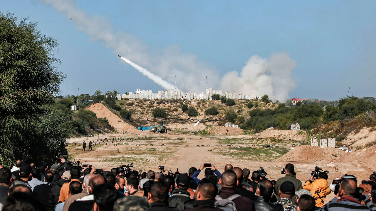 People watch as rockets are fired during a military drill by Palestinian Islamist movement Hamas and other Palestinian armed factions in Gaza City on December 29, 2020. (Photo by MAHMUD HAMS / AFP) (Photo by MAHMUD HAMS/AFP via Getty Images)