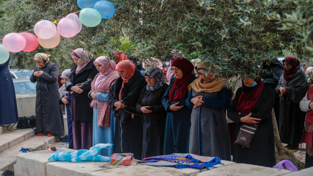 Palestinian women worshippers gather to attend the prayers of Eid al-Fitr, the Muslim holiday which starts at the conclusion of the holy fasting month of Ramadan, outside the closed Aqsa mosque complex in Jerusalem's old city early on May 24, 2020. - Muslims around the world began marking a sombre Eid al-Fitr, many under coronavirus lockdown, but lax restrictions offer respite to worshippers in some countries despite fears of skyrocketing infections. Jerusalem's Al-Aqsa mosque, Islam's third holiest site, w