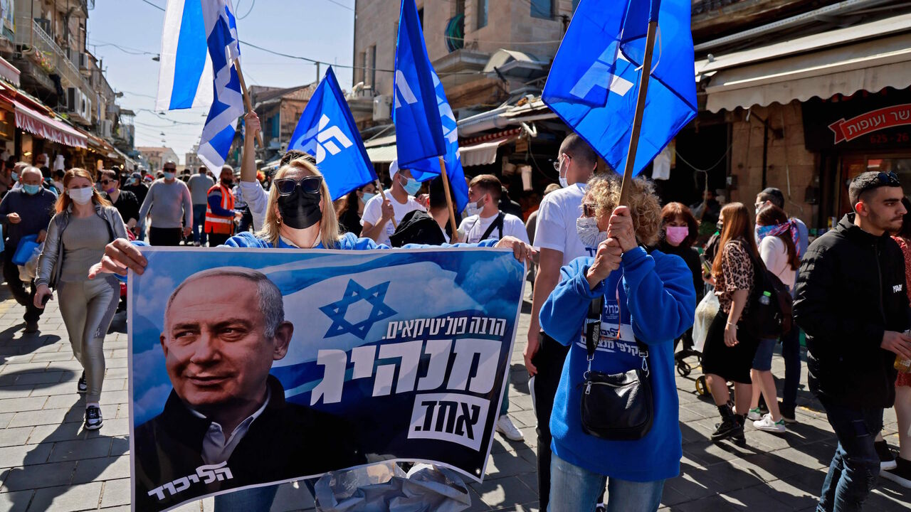 Supporters of Israeli Prime Minister Benjamin Netanyahu campaign at the Mahane Yehuda market in Jerusalem on February 26, 2021 ahead of the March 23 Israel general election. - Israel will hold its fourth general election in less than two years, on March 23. (Photo by MENAHEM KAHANA / AFP) (Photo by MENAHEM KAHANA/AFP via Getty Images)
