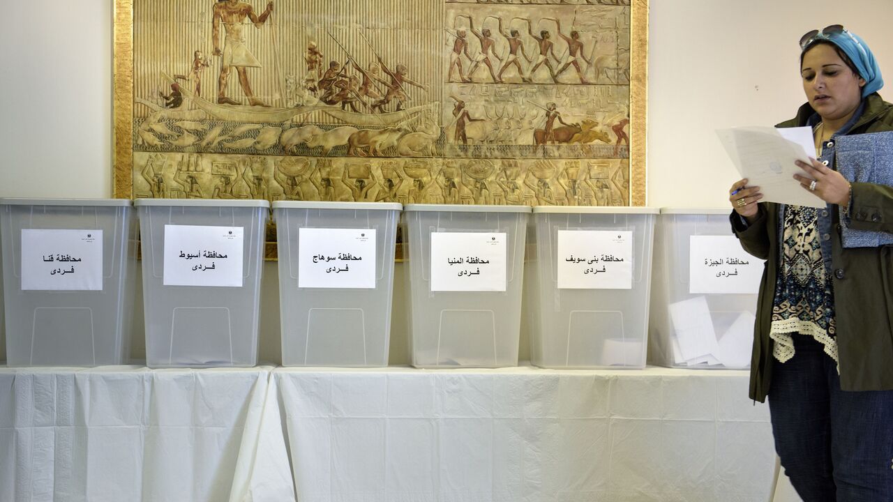A voter walks to her ballot box during voting for Egypt's parliamentary elections at the Egyptian embassy October 18, 2015 in Washington, DC.  Egyptians trickled in to polling stations Sunday to elect a new parliament that will tighten President Abdel Fattah al-Sisi's grip on power after he crushed all opposition since ousting his Islamist predecessor. The vote for the much-delayed 596-member parliament is being staged in two phases ending on December 2, with Egyptians abroad casting their votes for the fir