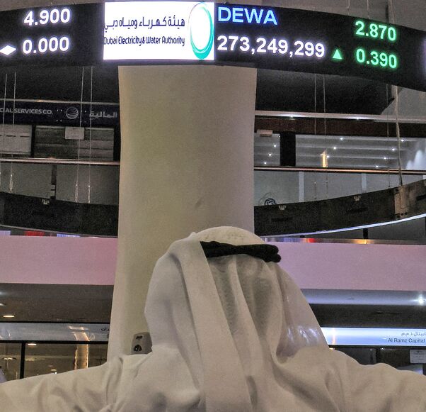 A man watches stock movements on a display at the Dubai Financial Market stock exchange in the Gulf emirate on April 12, 2022.