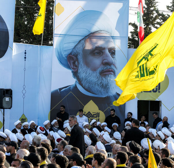 A large picture of Naim Qassem (C), current leader of the Lebanese Shiite movement Hezbollah, is displayed near another of the group's slain longtime leader Hassan Nasrallah during a ceremony marking the first anniversary of Israel's assassination of Nasrallah and other group leaders, in the town of Deir Qanoun al-Nahr near Tyre in southern Lebanon on September 27, 2025. The Iran-backed group, weakened by a deadly war with Israel last year, has organised a series of commemorative events to mark Nasrallah's 
