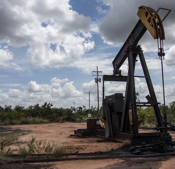 A pump jack stands near an oil spill at a facility in Venezuela.