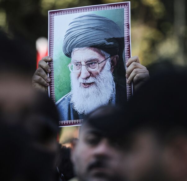 A protester holds up a portrait of Iran's Supreme Leader Ayatollah Ali Khamenei during a demonstration near the Iranian Embassy in Baghdad, on Jan. 16, 2026.