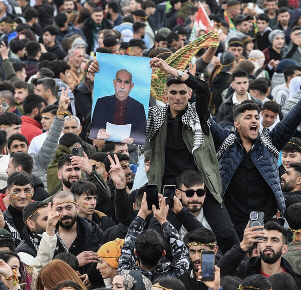 A man holds a poster of Abdullah Ocalan, Turkish-jailed founder of the Kurdistan Workers Party (PKK), during a gathering of Turkish Kurds for Nowruz celebrations in Diyarbakir, southeast Turkey, on March 21, 2025. 