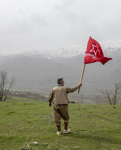 A armed Kurdish Peshmerga of the Komala party waves the Komala flag in a ceremony held in memory of Komala Martyrs' Day in Sidakan, Kurdistan Region of Iraq, on March 17, 2021.