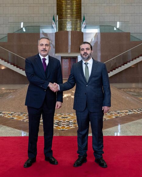 This handout photograph provided by the Turkish Foreign Ministry press service shows Turkish Foreign Minister Hakan Fidan (L) meeting with Syria's Foreign Minister Asaad al-Shaibani (R) in Damascus on Dec. 22, 2025. 