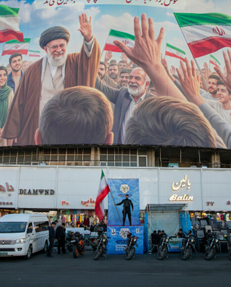 TEHRAN, IRAN - APRIL 23: A police officer stands holding a flag in Valiasr Square beneath a mural of the late Ayatollah Ali Khamenei on April 23, 2026 in Tehran, Iran. Earlier this week, U.S. President Donald Trump announced an extension of the current ceasefire between his country and Iran, despite Iran declining to attend the latest proposed round of peace talks in Islamabad. The focus of the war has shifted largely to the Strait of Hormuz, where both sides are trying to assert control over the critical m