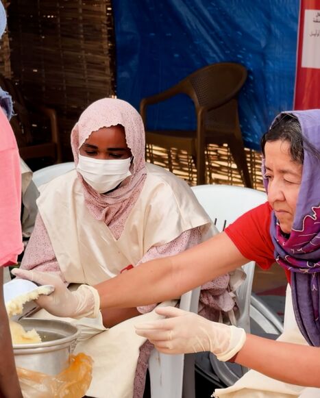 Janti Soeripto helps at a community kitchen serving hot meals to displaced families arriving from El-Fasher.