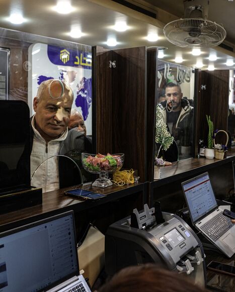 A Syrian citizen exchanges old banknotes for new notes released and distributed by the central bank, at a bank in the capital, Damascus, on Jan. 3, 2026.