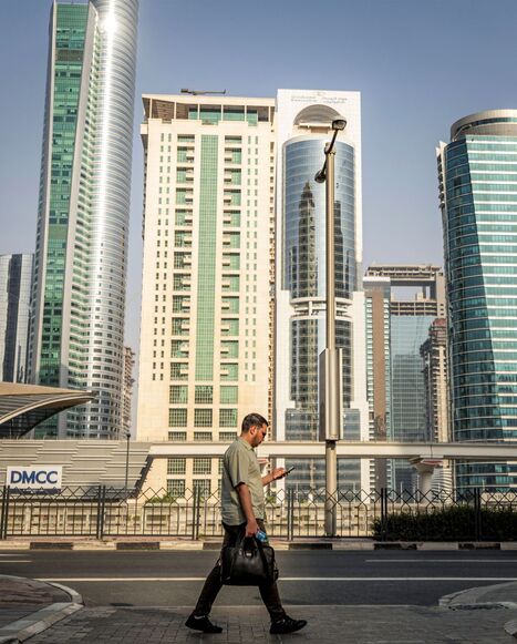 A man crosses a street while returning home from work, in Dubai on June 23, 2026. (Photo by FADEL SENNA / AFP via Getty Images)