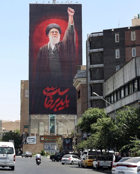 Motorists drive past a billboard bearing a picture of Iran's slain supreme leader Ali Khamenei, ahead of his funeral in Tehran on July 3, 2026. Iranian leaders began paying their respects on July 3 before the coffin of the country's late supreme leader Ali Khamenei, killed in the US-Israeli strikes that triggered the Middle East war, as Tehran prepared for a vast funeral. Khamenei's body arrived at Tehran's Grand Mosalla on July 3 ahead of ceremonies which are expected to draw millions. (Photo by AFP via Ge