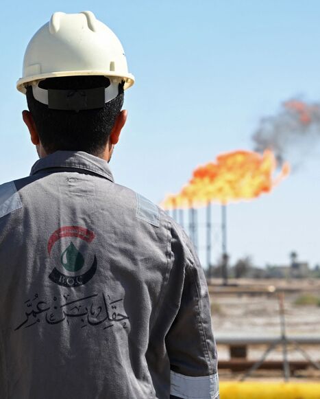 a worker inspects an oil field in Iraq