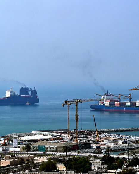 Ships are docked along a pier at the Khor Fakkan Container Terminal, the only natural deep-sea port in the region and one of the major container ports in Sharjah Emirate, along the Gulf of Oman on July 14, 2026.