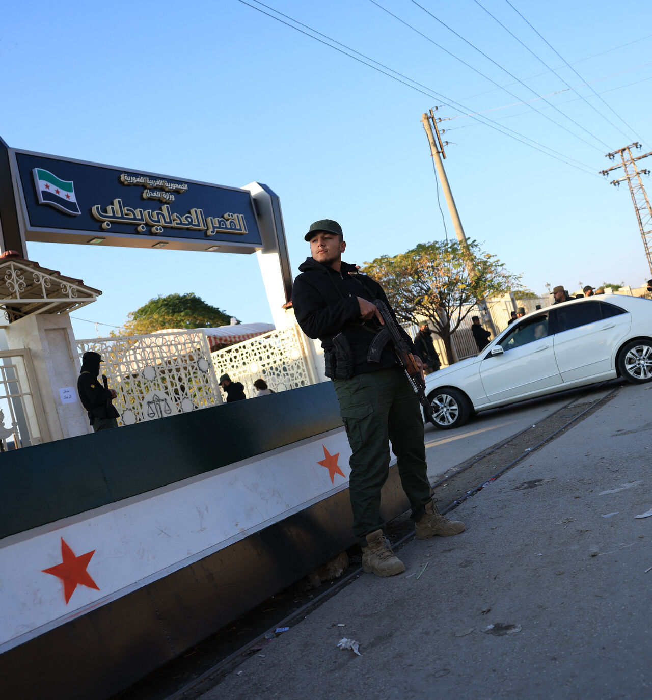 Security personnel from the Syrian Ministry of Interior stand outside the Justice Palace ahead of the first trial of more than a dozen suspects linked to massacres that left hundreds dead in Syria's Alawite coastal heartland earlier this year, in Aleppo on November 18, 2025. The first trial of more than a dozen suspects linked to massacres that left hundreds dead in Syria's Alawite coastal heartland earlier this year began on November 18, an AFP journalist in the courtroom said. The massacres in March, whic