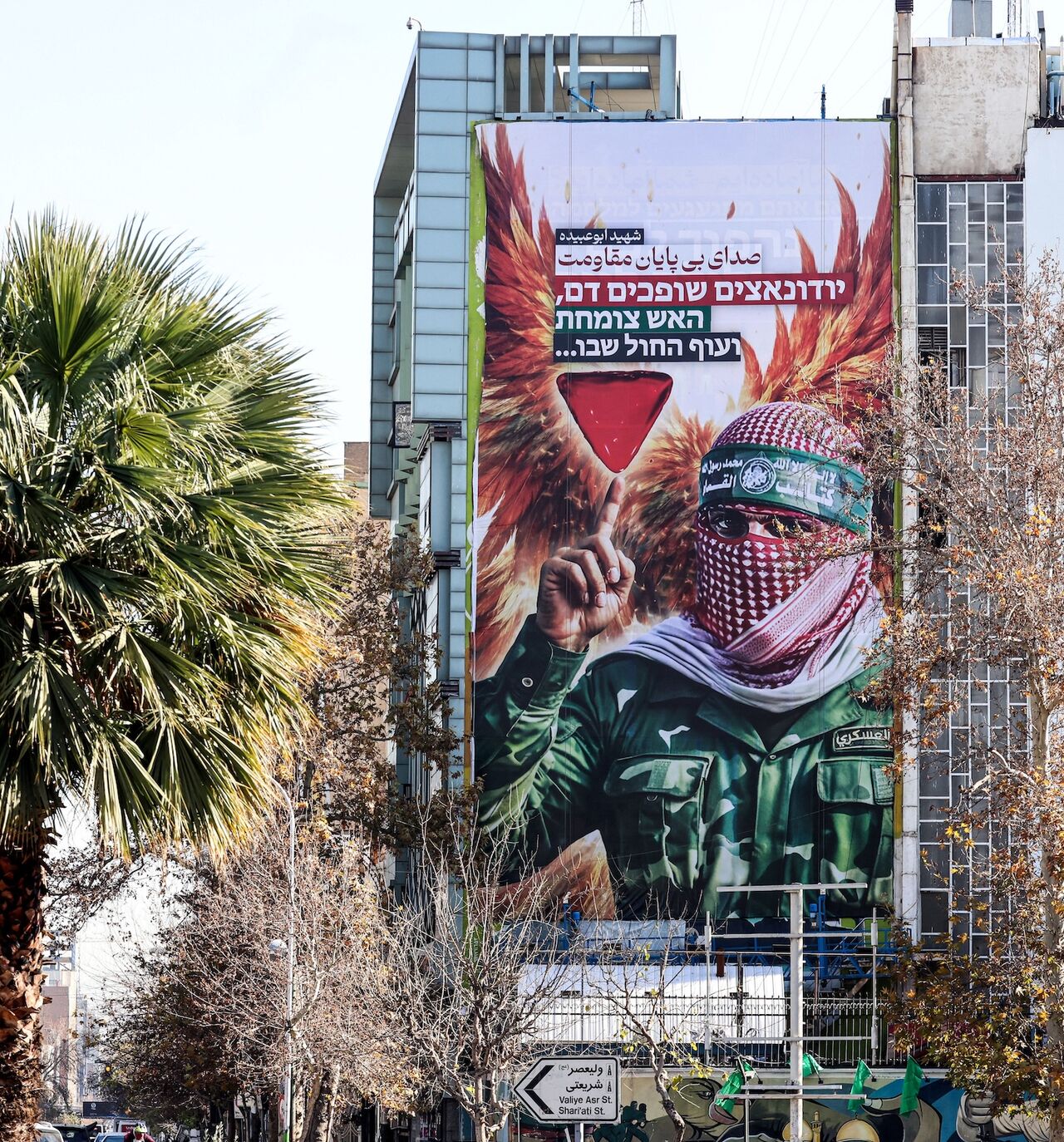 A large anti-Israeli banner portraying an image of a Palestinian fighter and the slogan in Persian and Hebrew, "Endless Voice of Resistance," is erected in Palestine Square in Tehran on Dec. 31, 2025, after Israel's Mossad spy agency issued a direct call urging Iranians to press on with protests. 