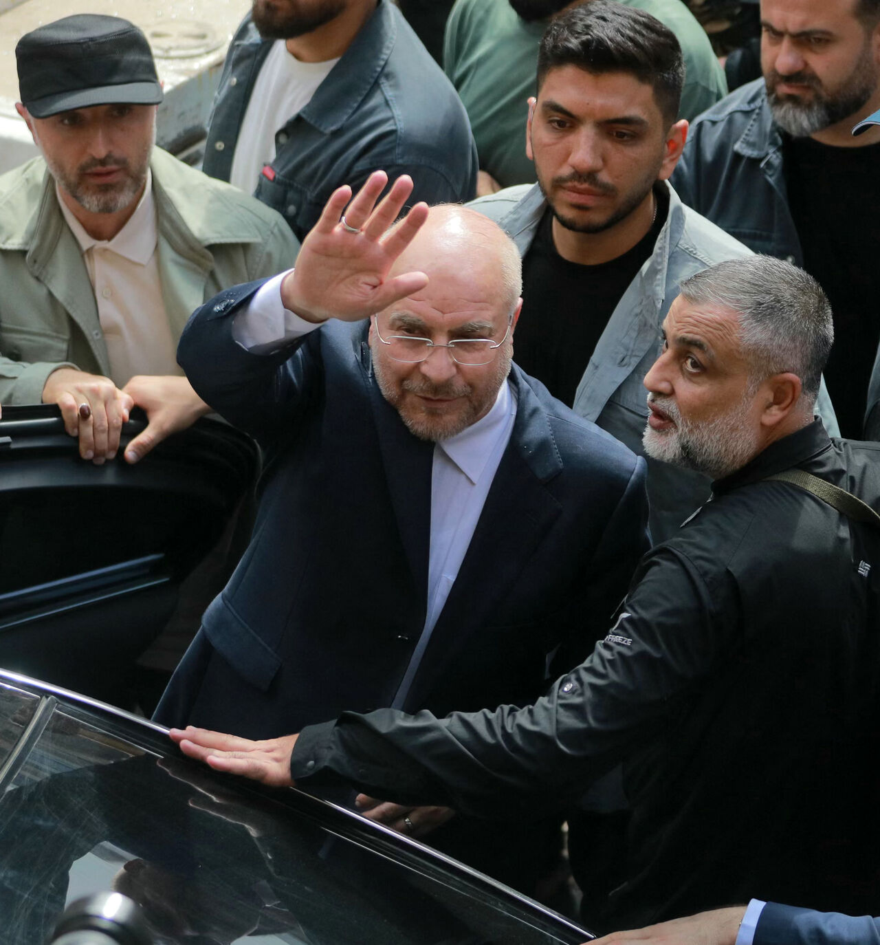 Iran's Parliament Speaker Mohammad Bagher Ghalibaf (C) waves as he returns to his car after visiting the site of an Israeli airstrike that targeted Beirut's Basta neighbourhood, on October 12, 2024. At least 22 people were killed in Israeli strikes on a densely populated area of central Beirut on October 10, the Lebanese health ministry said, with a security source saying a Hezbollah figure was the target. (Photo by Ibrahim AMRO / AFP) (Photo by IBRAHIM AMRO/AFP via Getty Images)