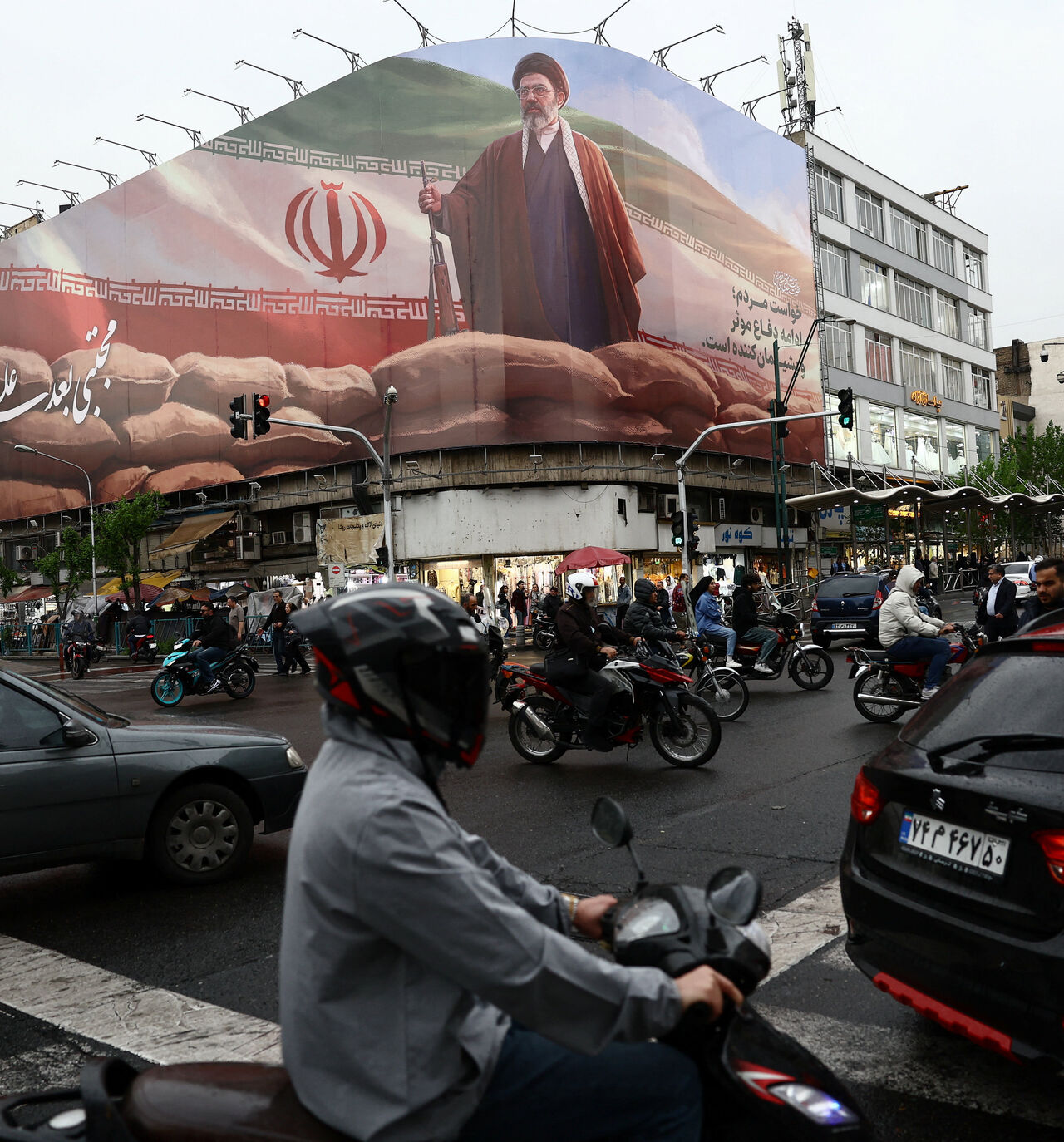 People ride motorcycles near a billboard featuring an image of Iran's new Supreme Leader Mojtaba Khamenei, amid a ceasefire between U.S. and Iran, in Tehran, Iran, April 20, 2026. Majid Asgaripour/WANA (West Asia News Agency) via REUTERS