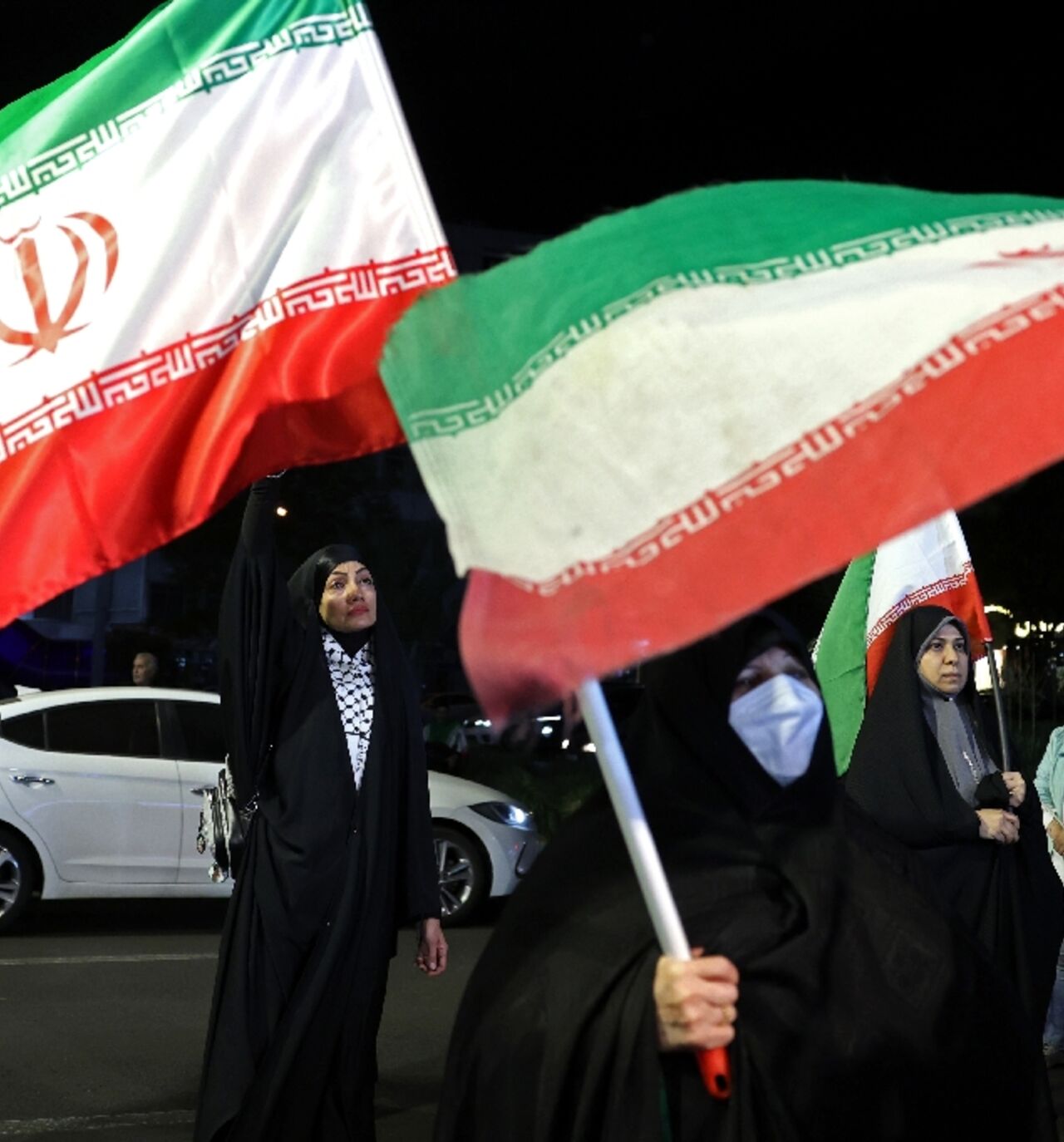 Women hold Iran's national flags during an anti-US and Israel protest in Tehran 