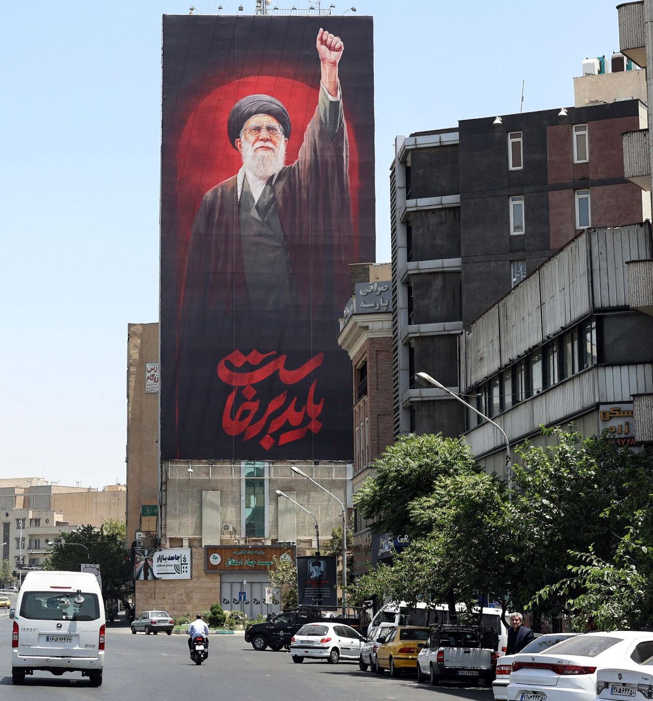 Motorists drive past a billboard bearing a picture of Iran's slain supreme leader Ali Khamenei, ahead of his funeral in Tehran on July 3, 2026. Iranian leaders began paying their respects on July 3 before the coffin of the country's late supreme leader Ali Khamenei, killed in the US-Israeli strikes that triggered the Middle East war, as Tehran prepared for a vast funeral. Khamenei's body arrived at Tehran's Grand Mosalla on July 3 ahead of ceremonies which are expected to draw millions. (Photo by AFP via Ge
